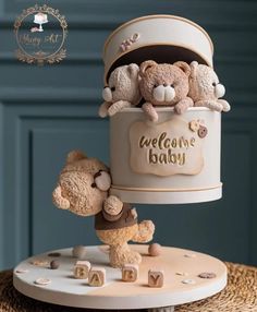 there is a cake with teddy bears on it and the words welcome baby written in gold