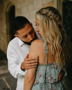 a man and woman embracing each other in front of a building