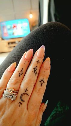 a woman's hand with two tattoos on it and a ring in the middle