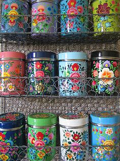 many colorful tins are lined up on the shelf