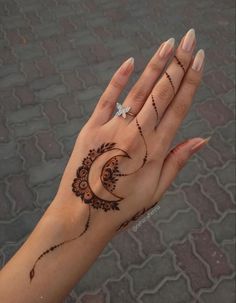 a woman's hand with henna tattoos on it