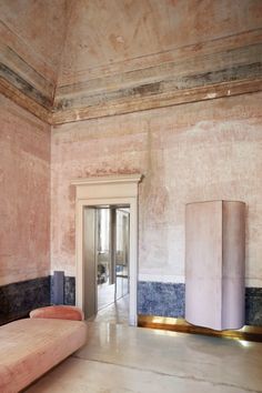 an empty room with pink walls and marble floors