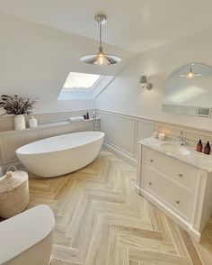 a bathroom with a tub, sink and mirror in it's center wall is shown