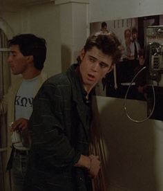 the young man is standing in front of an old tv