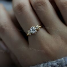 a woman's hand with two diamond engagement rings on top of her finger,