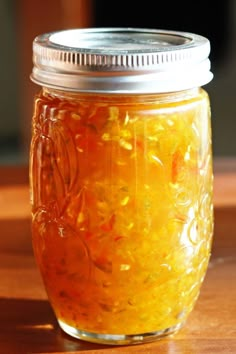 a jar filled with liquid sitting on top of a wooden table