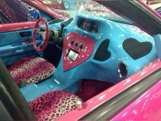 the interior of a pink and blue car with hearts on it's dash board