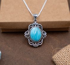 Discover the tranquil beauty of the sea encapsulated in our Ocean's Whisper Silver Pendant, featuring a mesmerizing oval Larimar gemstone at its core. This pendant is a symphony of design, where the soothing blue shades of the Larimar stone are cradled by an intricately crafted silver embrace, reminiscent of ocean waves and sea foam. Key Features: Serene Oval Larimar Gemstone: The pendant is adorned with a smooth, oval Larimar stone, its sky-blue color streaked with white patterns that mirror the calming essence of Caribbean waters. Each glance at this stone is a serene retreat for the mind, offering a peaceful escape within its azure depths. Ornate Silver Embellishments: The Larimar is set within a silver frame that boasts elegant scrollwork and beaded detailing, creating a vintage charm Larimar Cabochon Jewelry Gift, Color Streaks, Victorian Necklace, Larimar Jewelry, Larimar Pendant, Larimar Stone, Pendant For Women, Silver Frame, Sea Foam