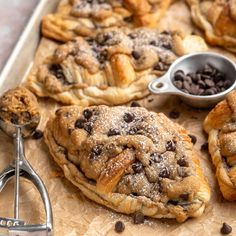 chocolate croissants and other pastries are on a baking sheet with a measuring spoon