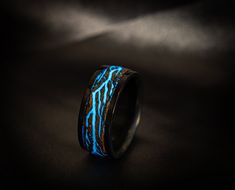 🔸🔸I used solid titanium combined with ash wood, luminous powder to create this ring. This ring is about 9mm wide, I can make to order about 7-12mm. The color of titanium is used using anodizing method so the color is very beautiful and durable. The ring looks rough but I have polished it very carefully so as not to cause any discomfort while wearing it! Titanium is completely safe for the skin, does not blacken fingers, does not cause allergies. ⚡The lightning part on the ring was created by m Glow Wedding Ring, Glow Rings, Black And Blue Rings For Men, Mens Wedding Band Black, Lightning Ring, Glow In The Dark Mens Ring, Glow In The Dark Ring, Lichtenberg Figures, Glow Ring