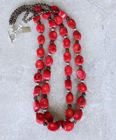 This eye-catching Necklace showcases 2 Strands of Bamboo Coral Oval Nuggets. The Nuggets are a lively coral-red with characteristic black markings, and have been cut with 2 flat sides and a flat round circumference. The structure is both uncommon and attractive. The Coral is slightly graduated — ranging from 11-by-14mm to 14-by-18mm. The stones have been polished to a glossy sheen. We've paired the Coral Nuggets with 17 6mm Oxidized Sterling Silver Rounds, adding subtle shine. The Sterling is co Bamboo Coral, Southwest Design, The Coral, Color Depth, Coral Red, Oxidized Sterling Silver, Toggle Clasp, Quartz Stone, Strand Necklace