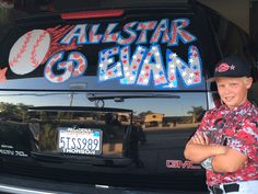 a young boy standing in front of a car with the words all star go evans on it