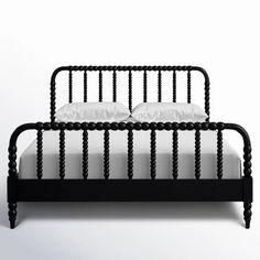 a black metal bed frame with white sheets and pillows on the headboard, in front of a plain background