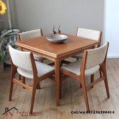 a wooden table with chairs around it and a bowl on top of the dining room table