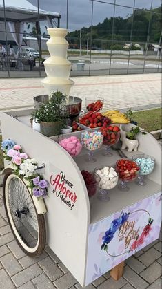 an ice cream cart is decorated with flowers and cakes