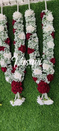 wedding flowers arranged in the shape of letters on green grass with white and red roses