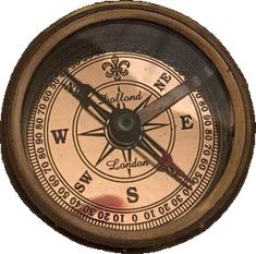 an old brass compass with the word west on it's face and two hands