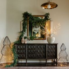 christmas decorations are displayed on the sideboard in this room