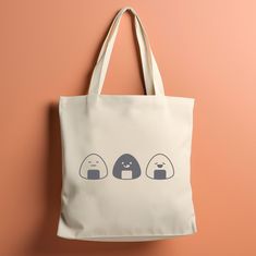 Looking for the perfect gift for any anime lovers or Japanese food enthusiasts? Our Japanese Rice Ball Tote Bag combines traditional charm with modern flair!  Made from durable, eco-friendly materials, this bag is spacious and versatile--perfect for grocery shopping, beach trips, or daily errands. Ideal for food lovers, anime lovers and eco-conscious shoppers. Elevate your accessory game and shop now for a unique addition to your collection! ‣ Tap here to head back to the shop: https://www.etsy.com/shop/FukuDesignsUS ‣ Follow us on: IG - https://www.instagram.com/fukudesignsus/ Pinterest - https://www.pinterest.com/fukudesignsus/ ‣ Reach out to us for any questions that you have about our items. We are here to provide quality products and service to you. SHIPPING AND PRODUCTION TIME Return Kawaii Rectangular Gift Bag, Kawaii Beige Bag As Gift, Kawaii Beige Bag For Gift, Kawaii Beige Bags Perfect For Gifts, Kawaii Rectangular Canvas Bag Gift, Kawaii Everyday Bag, Kawaii Everyday Portable Bag, White Kawaii Canvas Bag As Gift, Kawaii Portable Bag For Gift