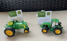 two toy tractors with tags attached to them