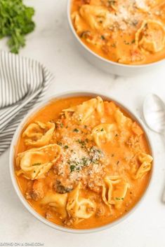 two bowls filled with pasta and meat soup