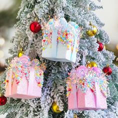 christmas tree decorated with pink and blue gift boxes on it's sides, surrounded by ornaments