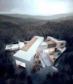 an aerial view of a house in the middle of a forest with trees around it