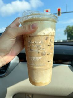 a person holding up a cup of coffee in their hand with the words that first sip feeling on it