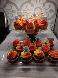 cupcakes are arranged on top of a cake stand with frosting and decorations