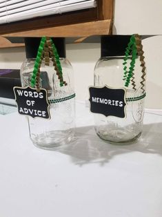 two glass jars with words on them sitting next to each other