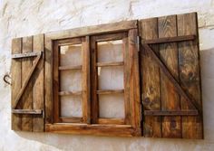 an old window with wooden shutters on the side of a building