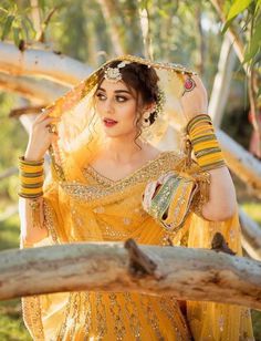 a woman in a yellow dress is posing for the camera with her hands on her head