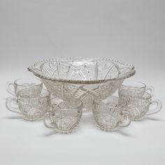 an antique glass bowl and six cups