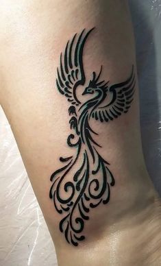 a black and white tattoo design on the side of a woman's leg with a bird