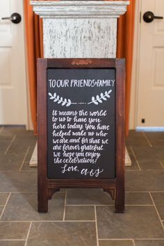 a chalkboard sign sitting on top of a tile floor