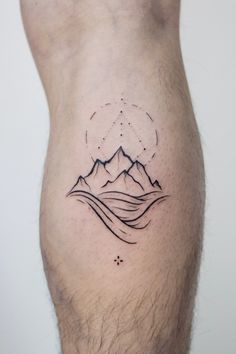 a man's lower leg with mountains and stars on it