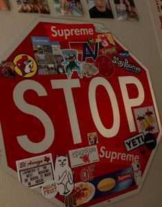 a stop sign with many stickers on it's face and some pictures above it