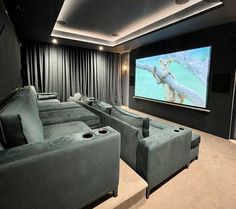 a home theater with two couches and a projector screen in front of it