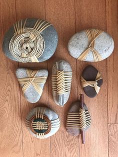 some rocks are sitting on the floor and tied up with string to make them look like they have been made out of wood