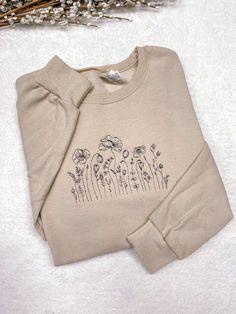 "Embroidered Wildflower Crewneck Sweatshirt, Cute Flower Hoodie. The sweatshirt is a soft spun crewneck and is very soft cotton poly blend, which is so comfy. Embroidered design will be as shown as in the picture. Personalization section: You will need to choose your thread color in this section. Item Description: Unisex Men Sizing Cotton and Polyester Pull On Long Sleeve Crewneck It takes 1-2 weeks to make and process orders for shipping. If you require it sooner, you will need to purchase the Cute Crew Neck Designs, Embroidery Design Sweatshirt, Crew Neck Design Ideas, Spring Crew Neck Sweater With Embroidered Logo, Spring Cream Cotton Sweatshirt, Spring Crew Neck Sweatshirt With Embroidered Logo, Spring Sweatshirt With Embroidered Logo And Crew Neck, Emboridary Designs Sweatshirt, Embroidered Cream Long Sleeve Sweatshirt