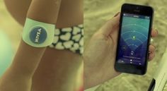 a person holding up a smart phone in front of their wristbands on the beach