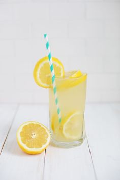 there is a glass with some lemons and a straw in it