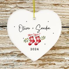 a white heart shaped ornament hanging on a wooden wall with the words,'christmas