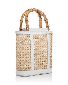 Discover the elegant Emerald Open Weave Rattan Mini Tote by Lusana. This stylish bag features an open top design with faux bamboo wood-tone handles and leather trim accents. Crafted from rattan and leather, this lightweight and versatile bag is perfect for any occasion. Double handles with a 4" drop 9"W x 3"D x 8.5"H Imported Luxury Basket Bag With Bamboo Handle, Leather Bucket Bag With Bamboo Handle For Shopping, Luxury Straw Bucket Bag With Bamboo Handle, White Leather Shoulder Bag With Bamboo Handle, Modern Summer Bags With Bamboo Handle, White Straw Bag With Top Handle, Leather Bucket Bag With Bamboo Handle For Daily Use, Modern Natural Straw Bag With Top Carry Handle, Modern Summer Straw Bag With Top Carry Handle