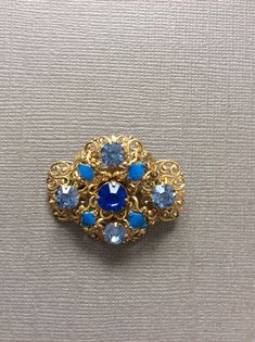 For sale I have a beautiful Czech brooch with claw set, blue rhinestones on a gold tone filigree frame.  CONDITION  In good vintage condition. Ornate Blue Brooches For Wedding, Ornate Blue Wedding Brooches, Ornate Blue Brooch For Formal Occasions, Antique Blue Jewelry With Brooch, Blue Costume Jewelry Brooch For Wedding, Vintage Sapphire Brooches For Gifts, Blue Victorian Brooches For Formal Occasions, Vintage Sapphire Brooches As Gift, Blue Victorian Brooch For Formal Occasions