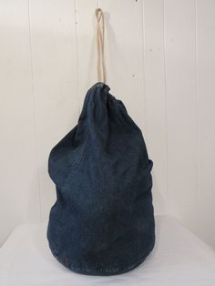 "Vintage 1940s or 50s denim knapsack, bag or duffle. Has rope drawstring. No label. In very good condition. Bag measures 27\" tall. Bottom is 14\" in diameter." Vintage Denim Bag With Pockets, Vintage Denim Blue Travel Bag, Vintage Everyday Denim Bag, Vintage Style Everyday Denim Bag, Everyday Vintage Denim Bag, Everyday Vintage Style Denim Bag, Vintage Upcycled Denim Bag, Vintage Denim Bags For Everyday Use, Vintage Denim Blue Bags For Everyday Use