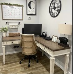 an office with a desk, chair and clock on the wall above it is shown