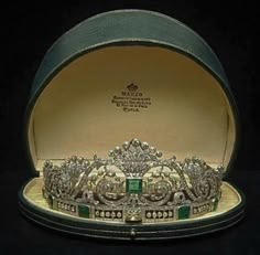 an ornately decorated tiara sits in its case