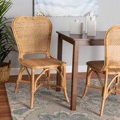 two wicker chairs sitting at a table with a potted plant next to it