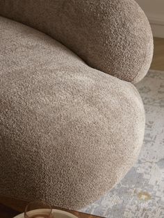 a close up of a couch on a wooden floor with a rug in the background